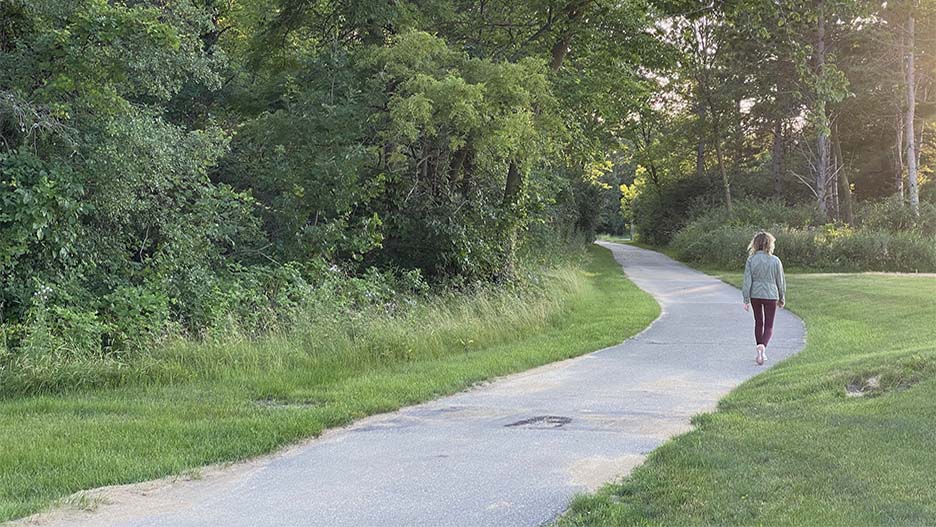  A person walking in ther distance on the University’s fitness trail that goes around the campus recreation multi-purpose fields