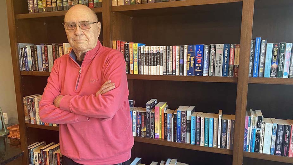 Retired Minnesota State University sociology chairman David Janovy, founder of Lifelong Learners, posing in front of a bookshelf